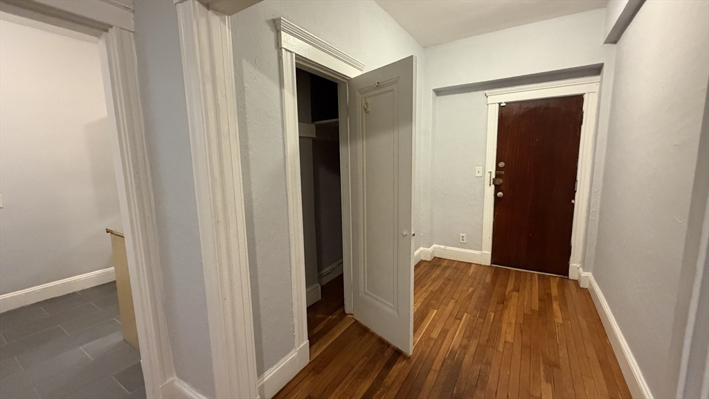1945 Commonwealth Avenue, Unit 4 Boston, MA 02135 - Photo 19 of 22 a view of a hallway with wooden floor and staircase
