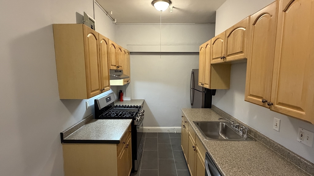 1945 Commonwealth Avenue, Unit 4 Boston, MA 02135 - Photo 2 of 22 a kitchen with a sink a stove and refrigerator