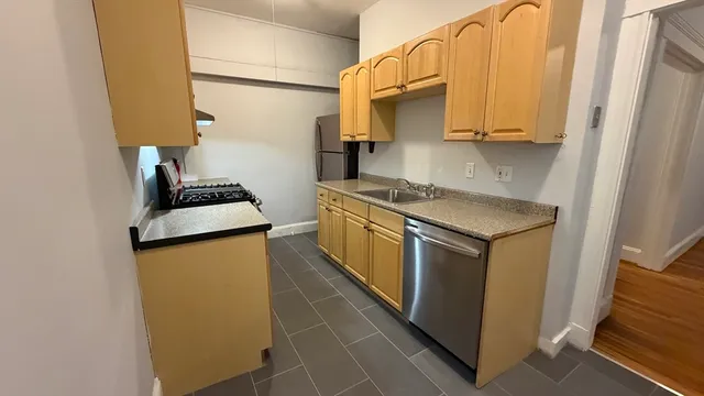 a kitchen with stainless steel appliances granite countertop a sink stove and refrigerator