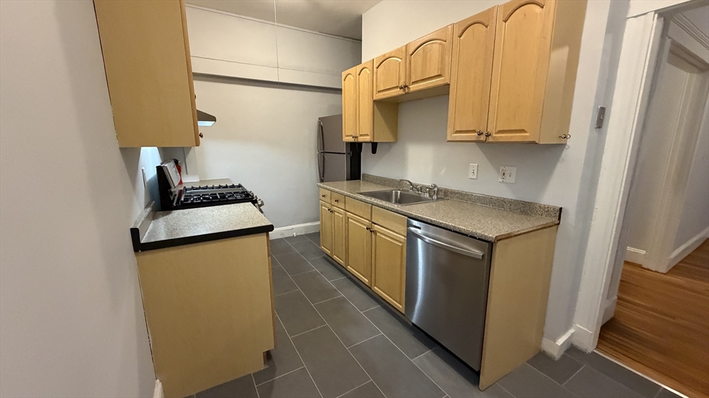 1945 Commonwealth Avenue, Unit 4 Boston, MA 02135 - Photo 21 of 22 a kitchen with stainless steel appliances granite countertop a sink stove and refrigerator