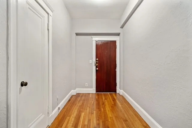 a view of a hallway with wooden floor