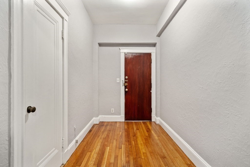 1945 Commonwealth Avenue, Unit 4 Boston, MA 02135 - Photo 5 of 22 a view of a hallway with wooden floor
