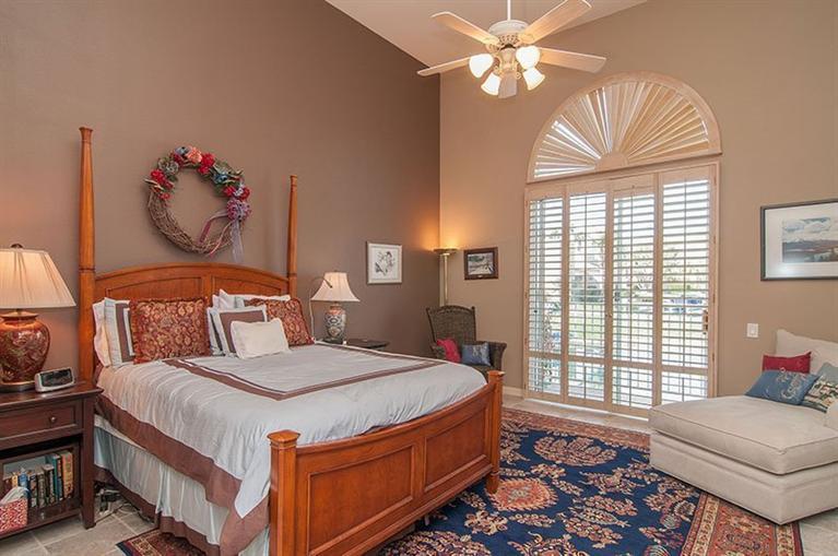 138 Lakeshore Drive Rancho Mirage, CA 92270 - Photo 17 of 24 a bedroom with a bed and a chandelier