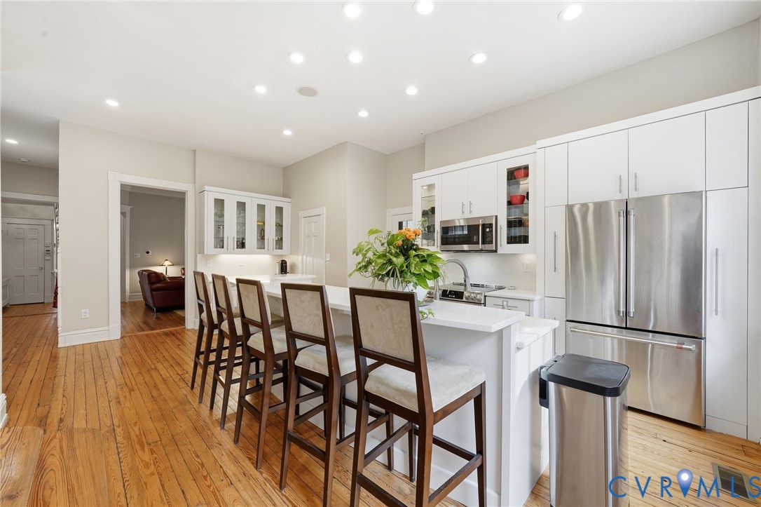 2005 Stuart Avenue Richmond, VA 23220 - Photo 11 of 29 a kitchen with stainless steel appliances a dining table chairs refrigerator and sink