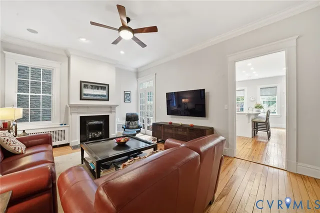 a living room with furniture a flat screen tv and a large window
