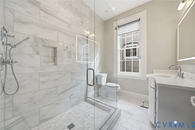 a spacious bathroom with a shower sink and mirror
