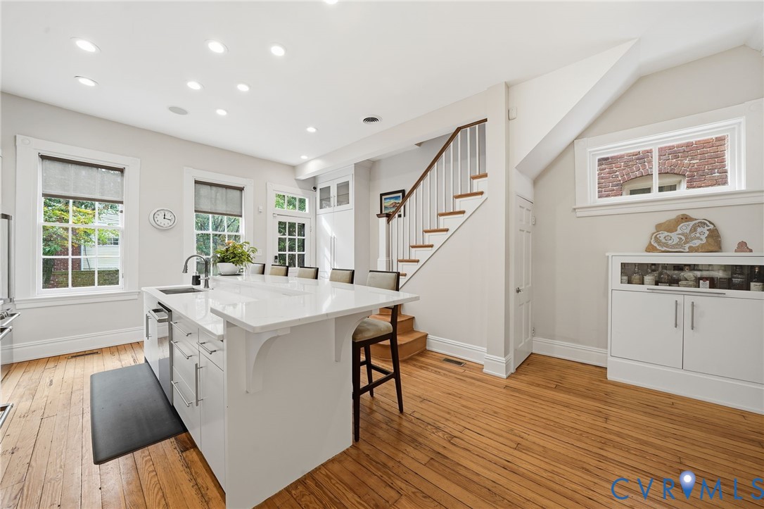2005 Stuart Avenue Richmond, VA 23220 - Photo 8 of 29 a large white kitchen with wooden floor and stainless steel appliances