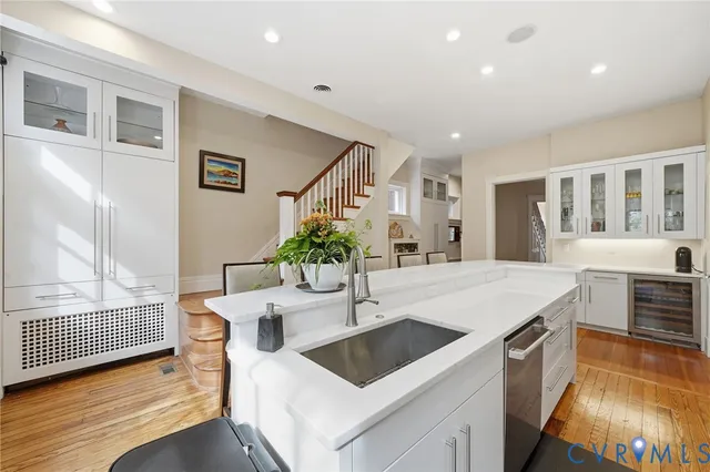 a kitchen with stainless steel appliances a dining table chairs refrigerator and sink