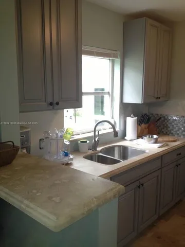 a kitchen with stainless steel appliances granite countertop a sink a stove and a granite counter top