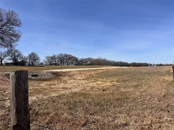 a view of a field with trees in the background