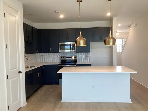 a kitchen with stainless steel appliances a sink a stove a refrigerator and cabinets