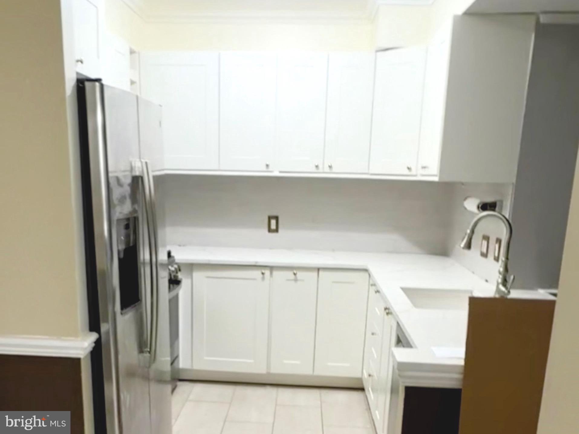 555 Massachusetts Avenue Northwest, Unit 815 Washington, DC 20001 - Photo 5 of 20 a kitchen with stainless steel appliances white cabinets and a refrigerator