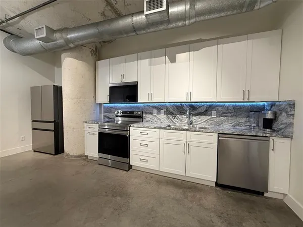 a kitchen with stainless steel appliances granite countertop a stove a sink and a refrigerator