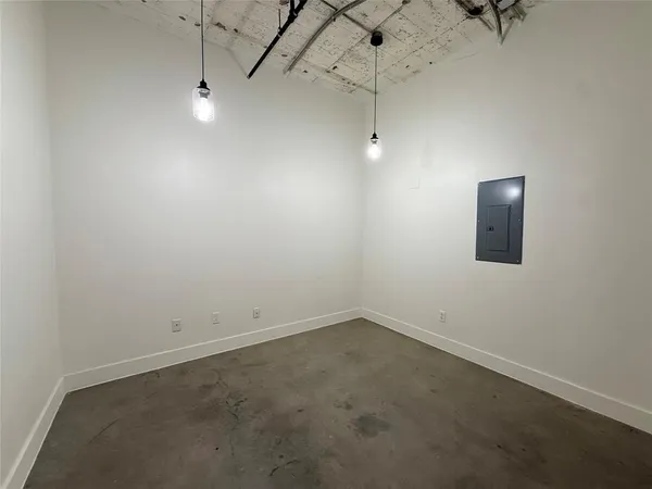 an empty room with a ceiling fan and carpet