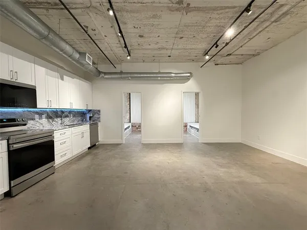 a view of a kitchen with stainless steel appliances granite countertop a stove a sink dishwasher and a stove