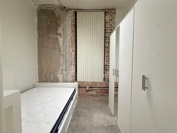 a bedroom with a bed and a window