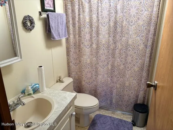 a bathroom with a granite countertop toilet and a sink