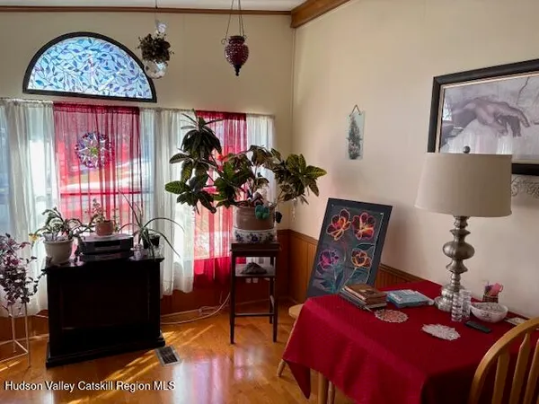 a view of a dining room with furniture a chandelier and wooden floor