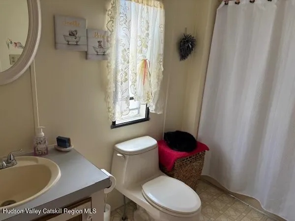 a white toilet sitting next to a bathroom sink and a tub