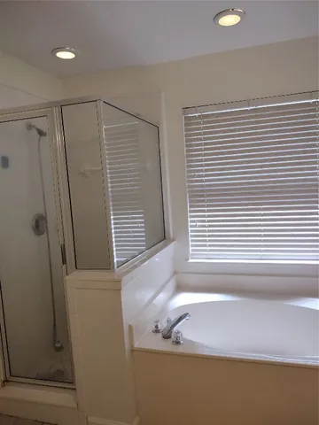 a bathroom with a bathtub a sink and a window