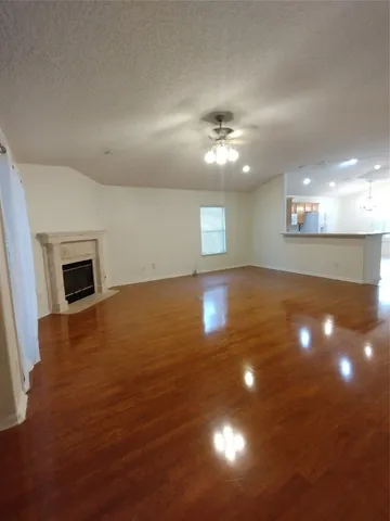 an empty room with windows and fireplace