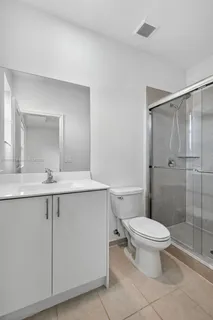 a bathroom with a shower a toilet and a sink