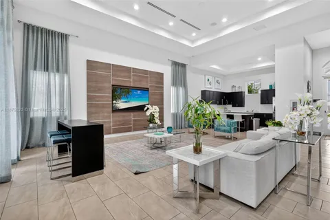 a kitchen with stainless steel appliances a dining table chairs and refrigerator