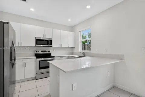 a kitchen with cabinets stainless steel appliances and a sink