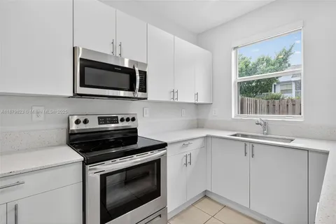 a kitchen with a refrigerator and white cabinets