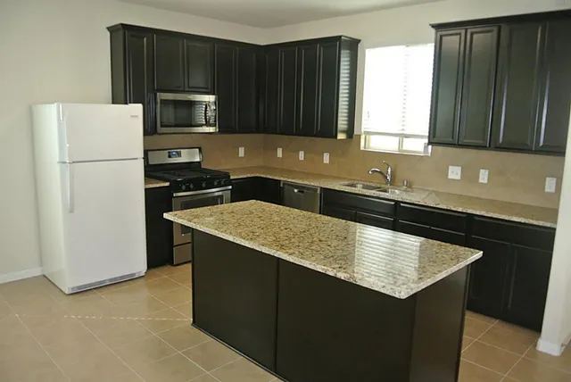 a kitchen with a sink a stove top oven and refrigerator