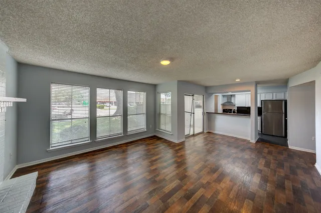 a view of empty room with wooden floor and fireplace
