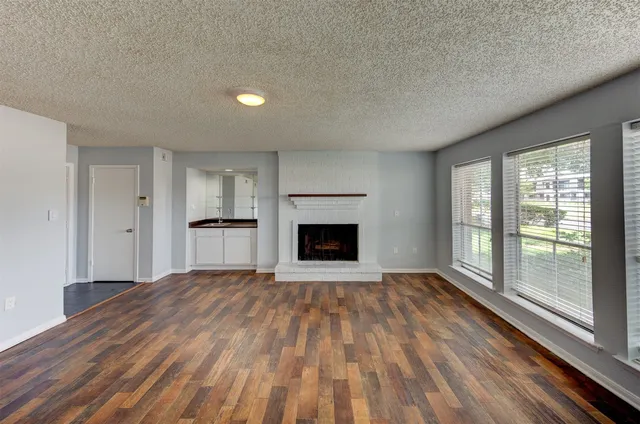 a view of an empty room with a fireplace and a window