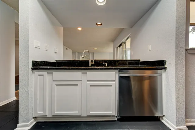 a view of a refrigerator a sink and cabinets