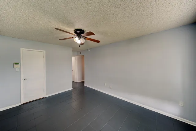 a view of an empty room with a chandelier fan