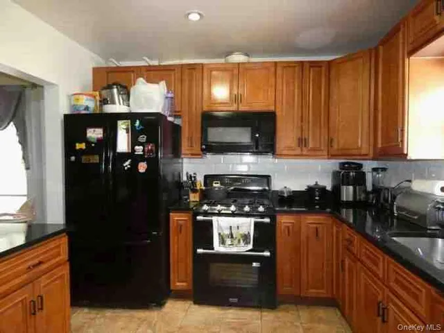 a kitchen with stainless steel appliances granite countertop a refrigerator and a stove top oven