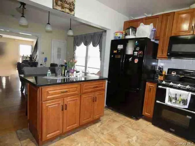 a kitchen with stainless steel appliances granite countertop a refrigerator and a sink