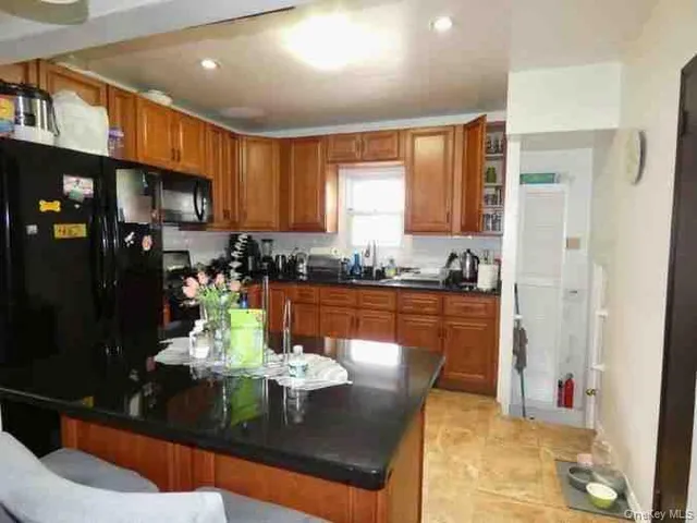 a kitchen with stainless steel appliances granite countertop a refrigerator a stove a sink dishwasher with a dining table and chairs