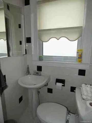a bathroom with a toilet sink and mirror