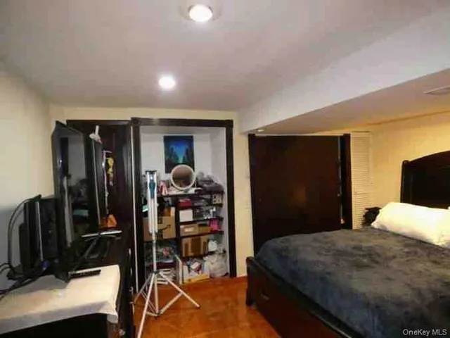 a bedroom with a bed and a flat tv screen on dresser