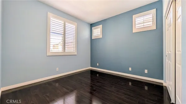 a view of a room with wooden floor and windows