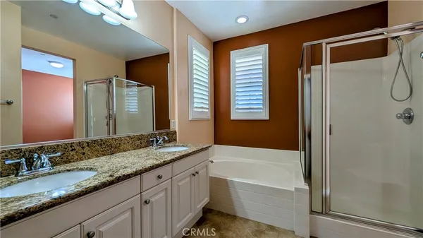 a bathroom with a granite countertop sink mirror and a bathtub