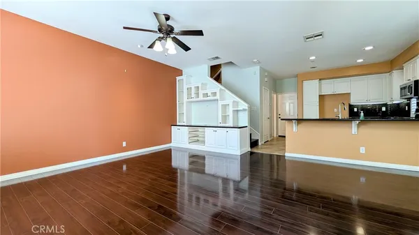 a view of a kitchen with wooden floor and a ceiling fan