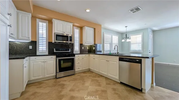 a kitchen with granite countertop a stove and a refrigerator