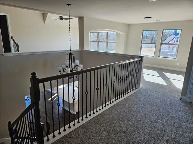 a view of staircase with lots of frames on wall and windows