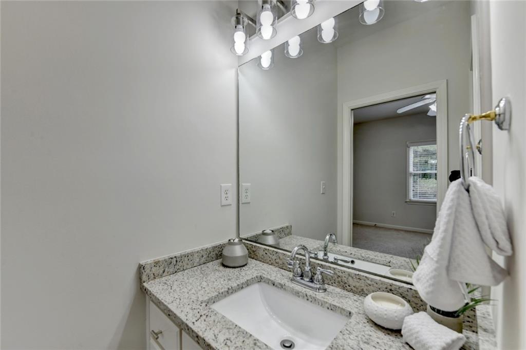 855 Autumn Close Alpharetta, GA 30004 - Photo 65 of 154 a bathroom with a granite countertop sink a mirror and vanity