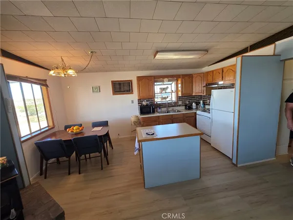 a living room with furniture and a dining table with kitchen appliances
