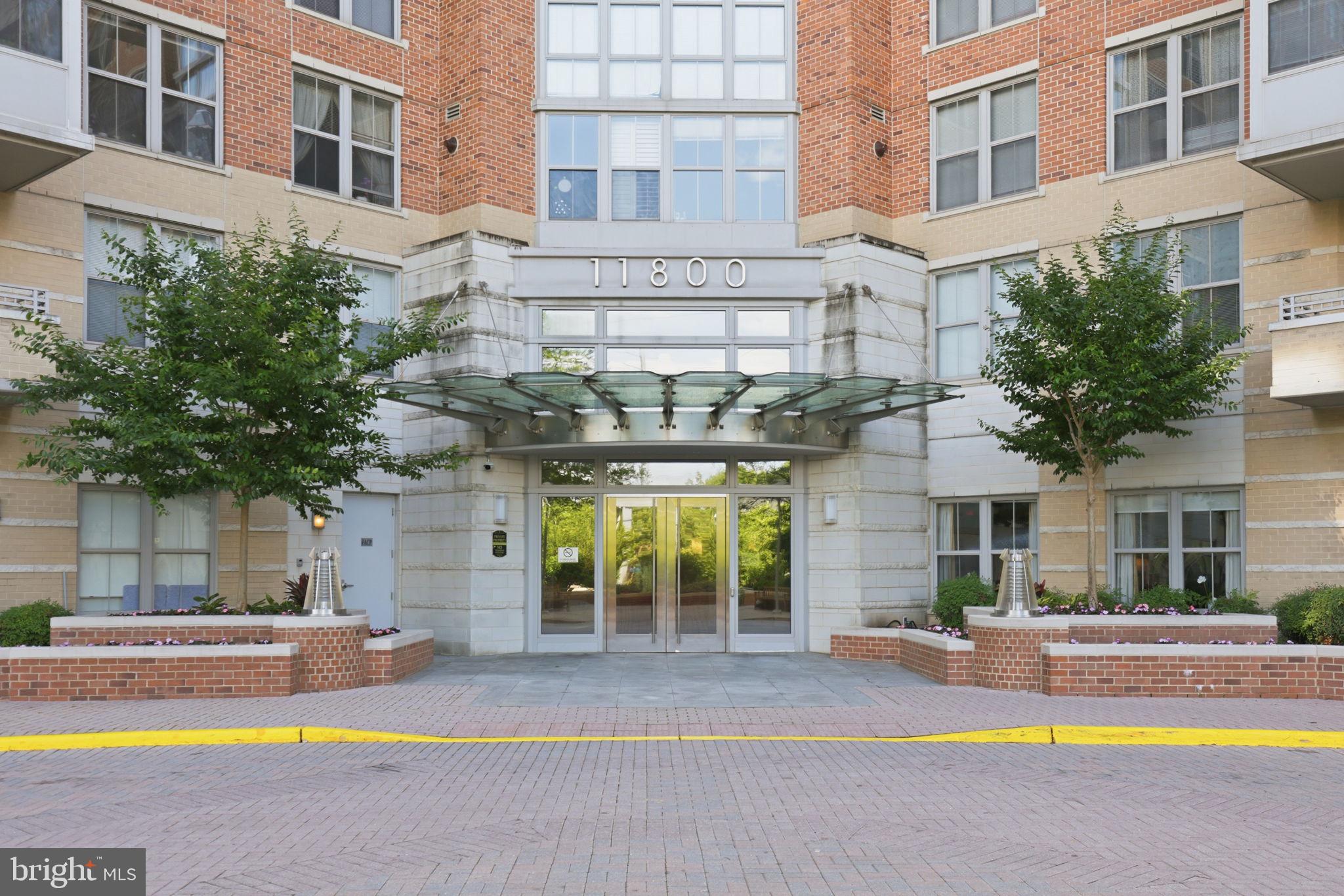 11800 Sunset Hills Road, Unit 218 Reston, VA 20190 - Photo 1 of 38 a view of house with a swimming pool and a large tree