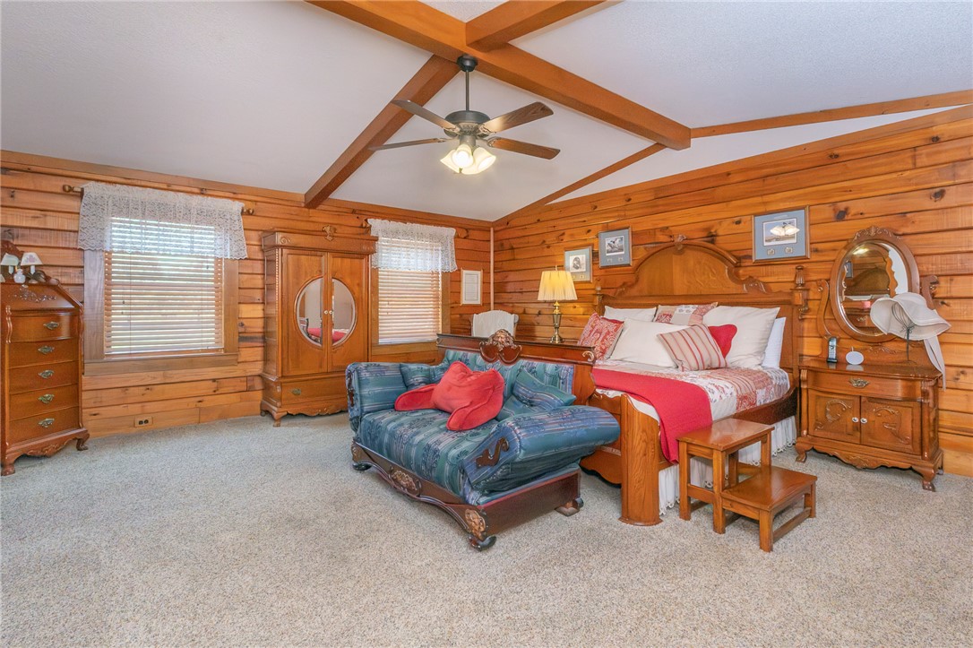 911 State Rd S-4-203 Belton, SC 29627 - Photo 23 of 49 Natural wood paneling and exposed ceiling beams define this inviting, comfortable bedroom space.