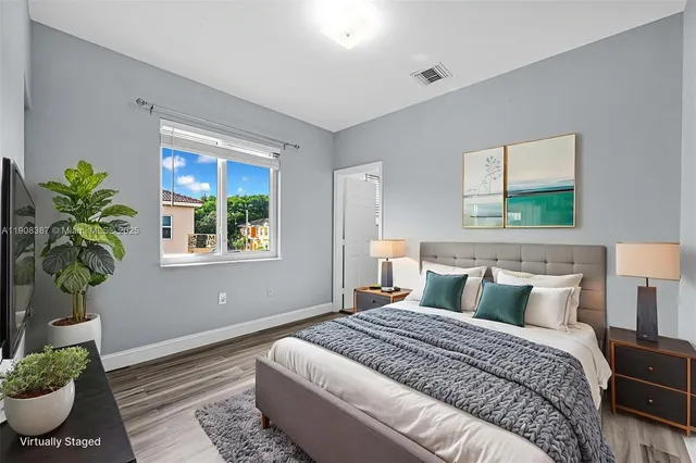 a view of an empty room with wooden floor and closet