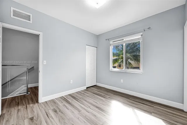 a bathroom with a toilet a sink and wooden floor